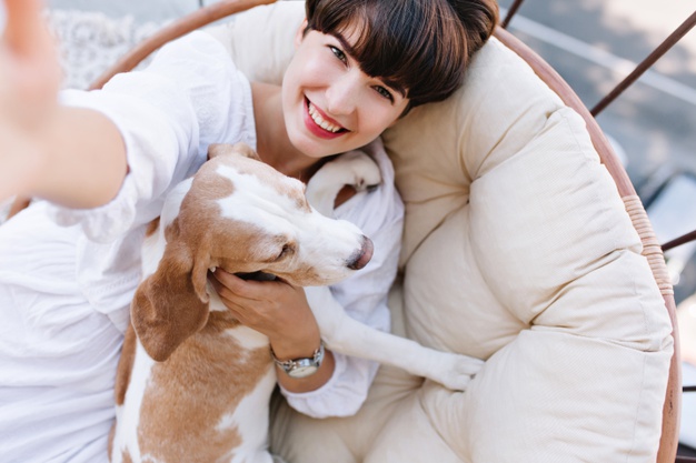 excited-girl-with-short-brown-hair-laughing-while-taking-photo-herself-with-beagle-dog_197531-4860