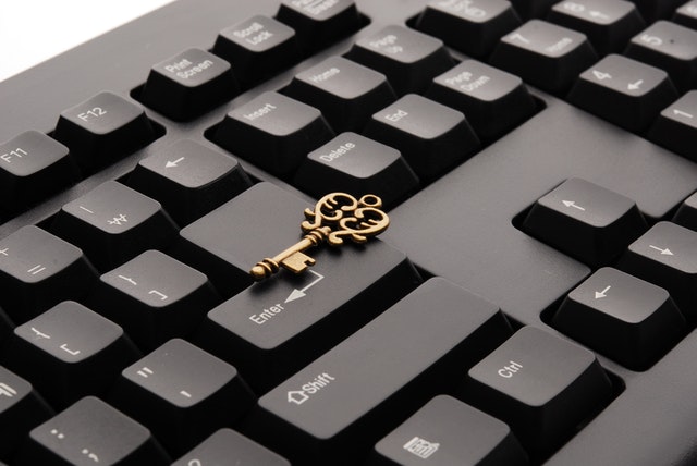 Zlatý kľúč položený na čiernej klávesnici od počítača.jpg